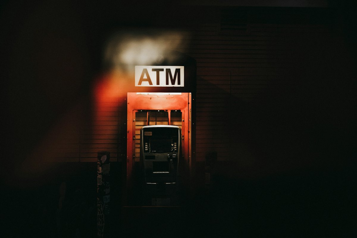 Cash machine glowing in a dark wall at night