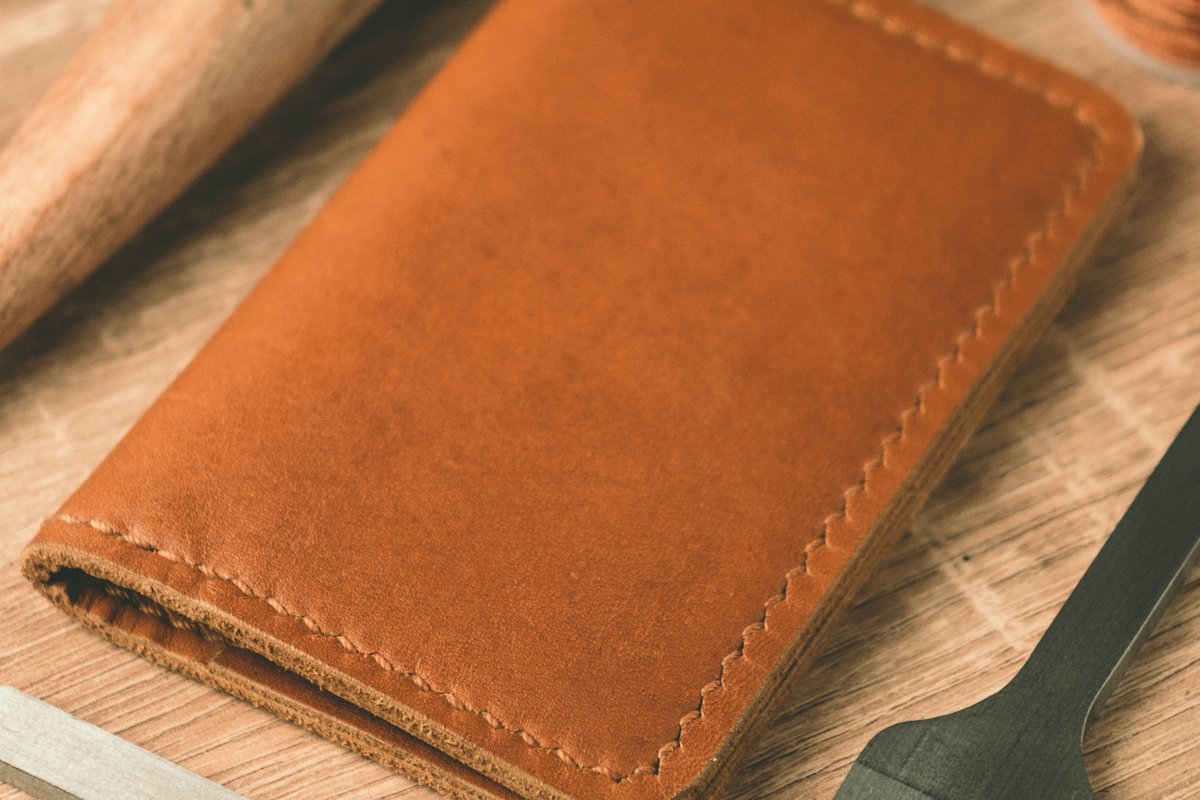 Brown leather wallet lying on a wooden surface