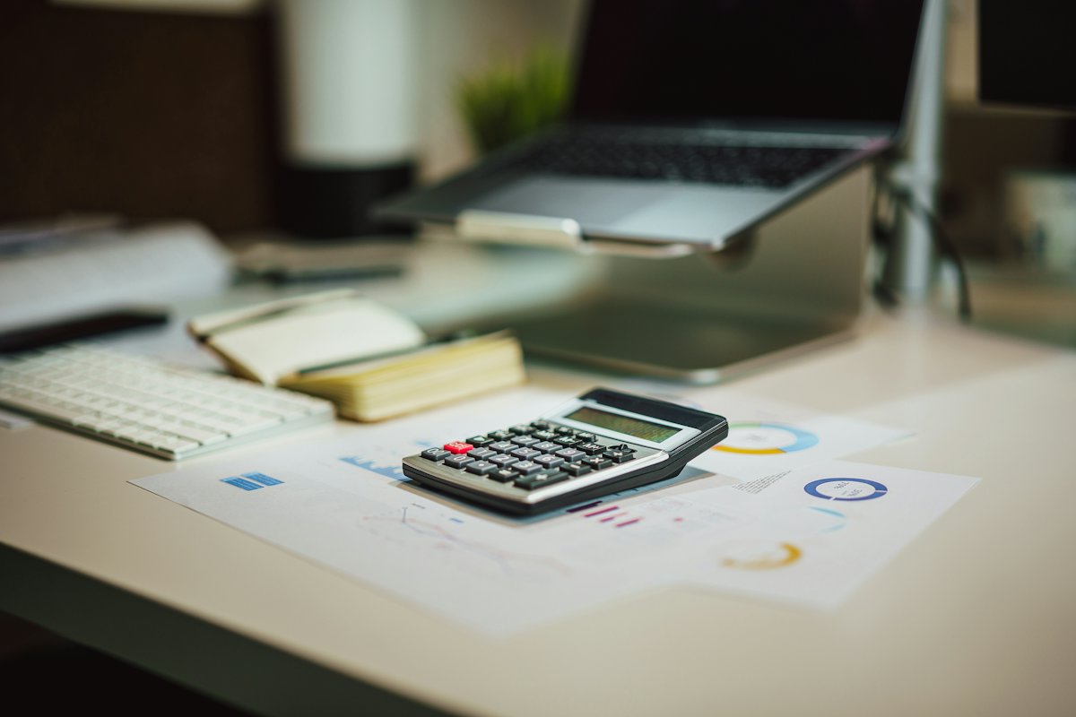 Calculator and printed reports on a bright office desk