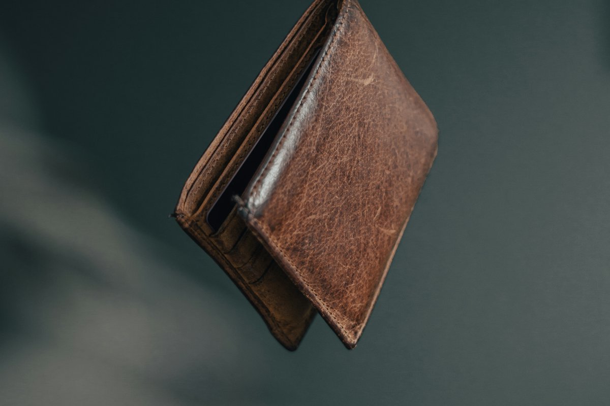 Worn brown wallet against a dark background