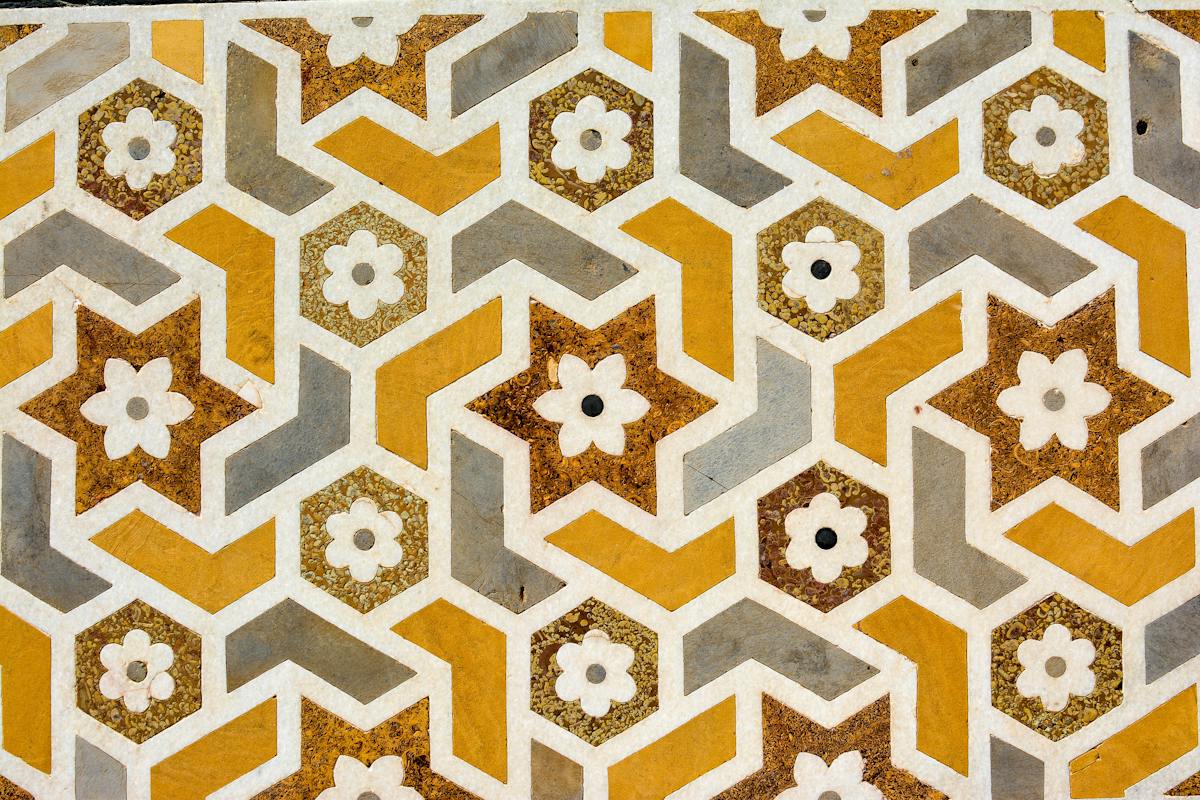 Repeating geometric star tiles in ochre and grey