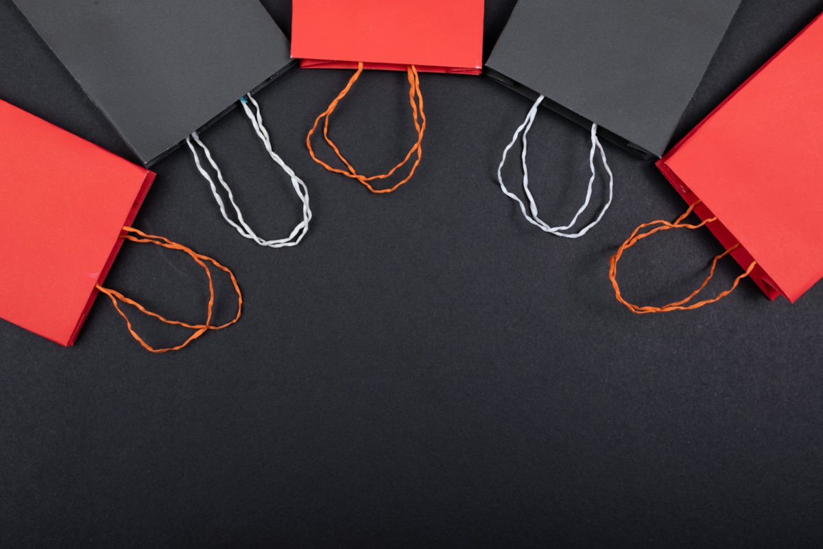 Red and white gift bags on a dark surface