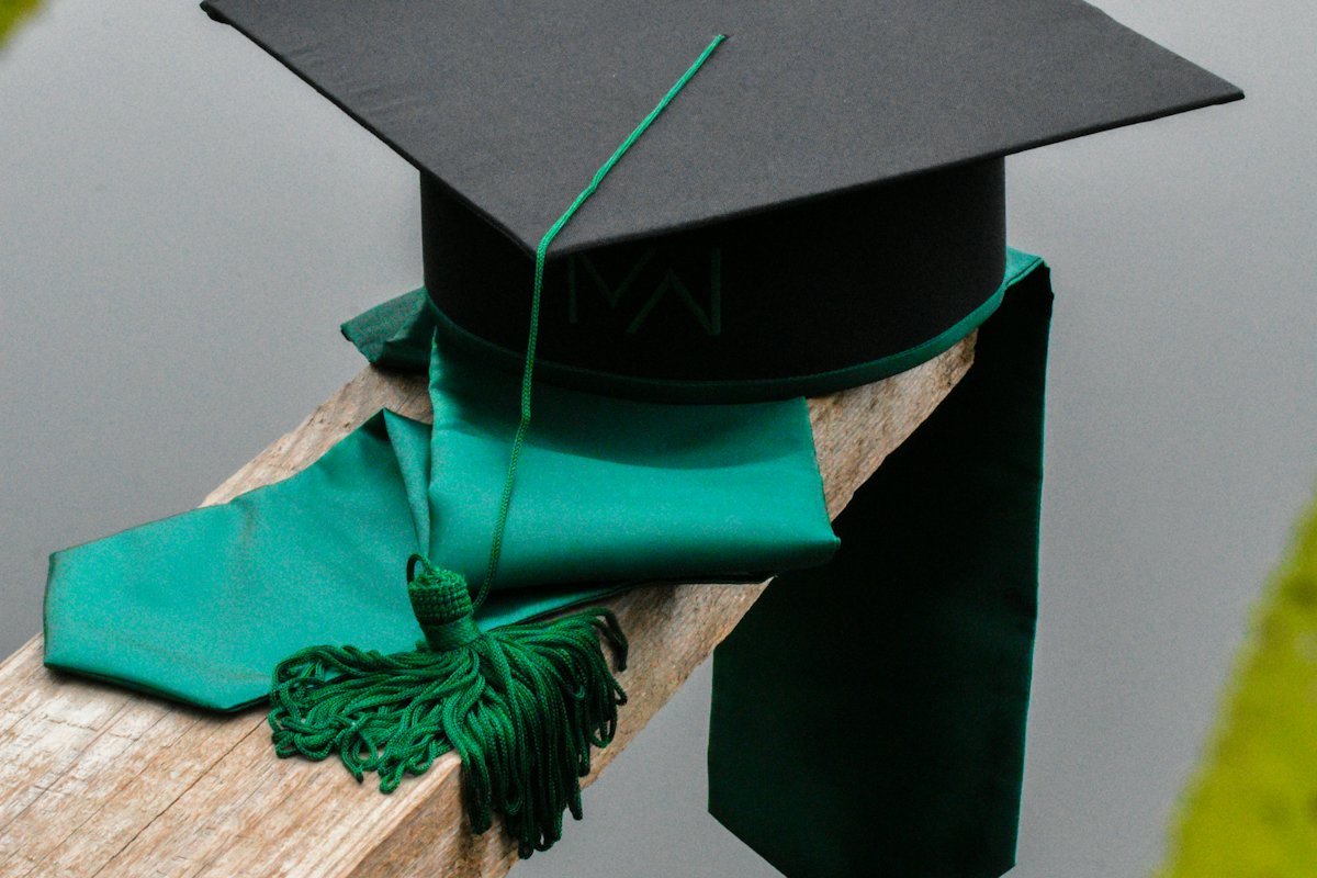 Graduation cap with a green tassel and stole