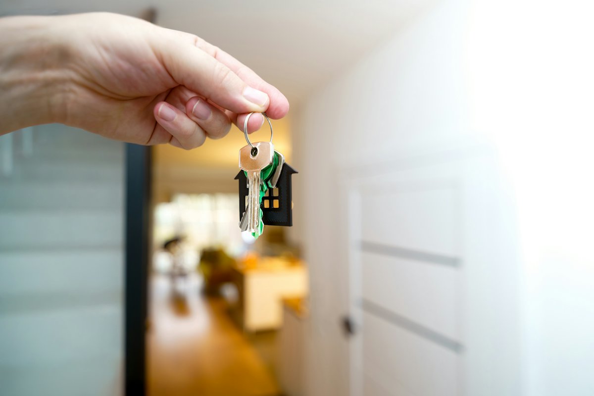 Hand holding house keys in a doorway