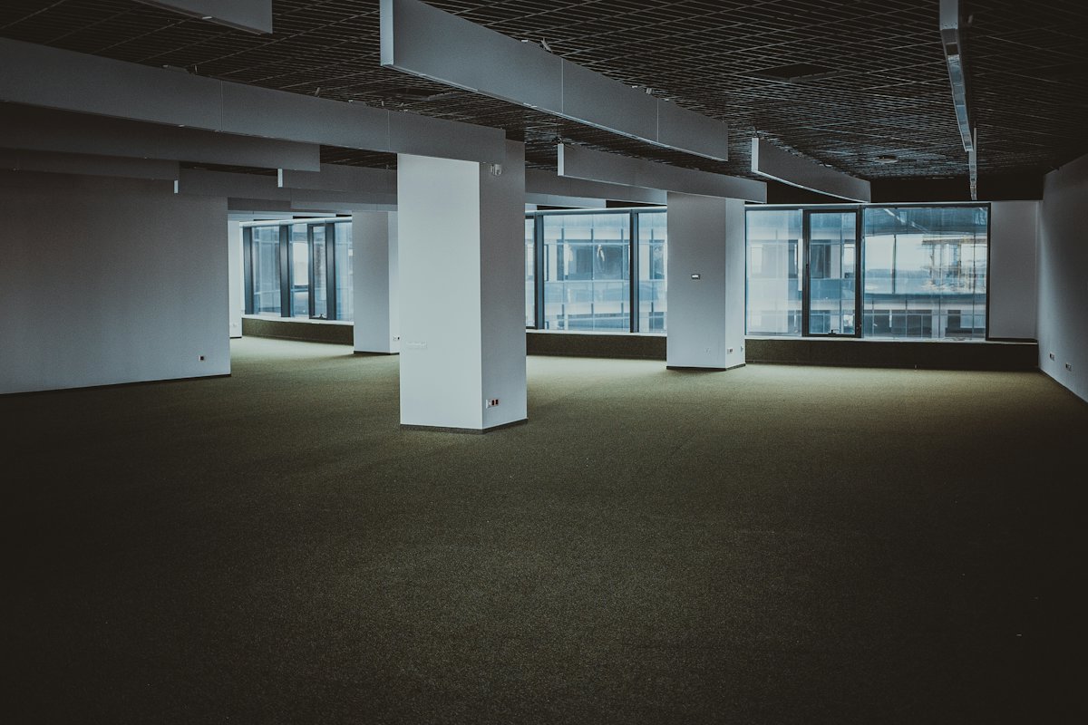 Empty open-plan office floor with large windows