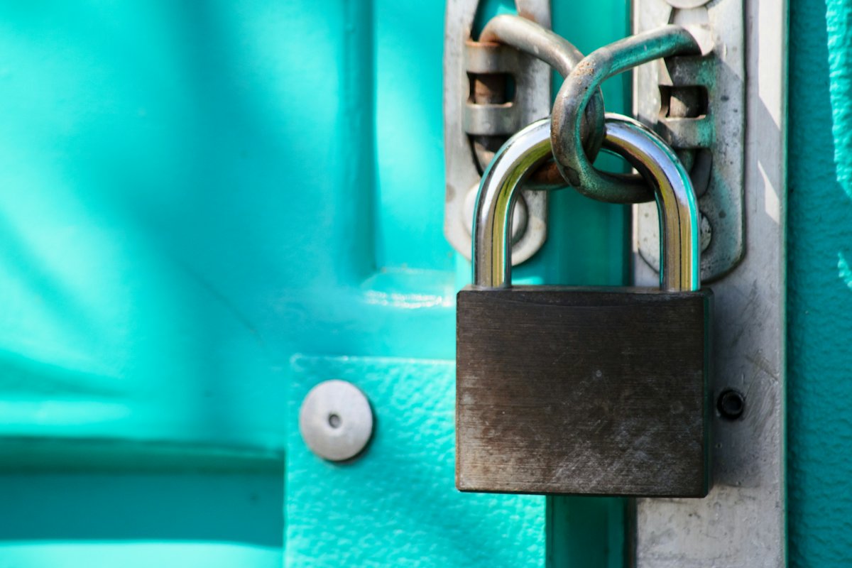Padlock on a teal painted door