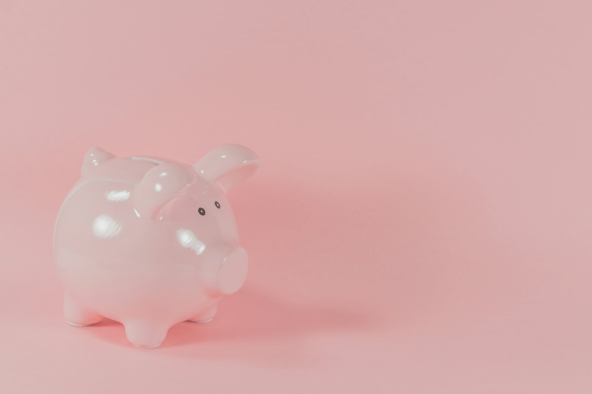 Translucent piggy bank on a soft pink background