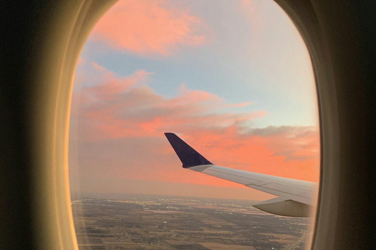 Aircraft wing seen through a window at sunset