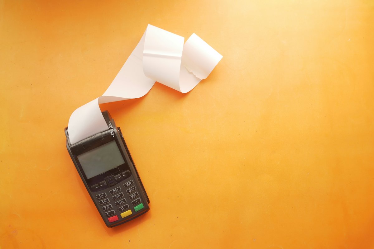 Card terminal printing a receipt on an orange background
