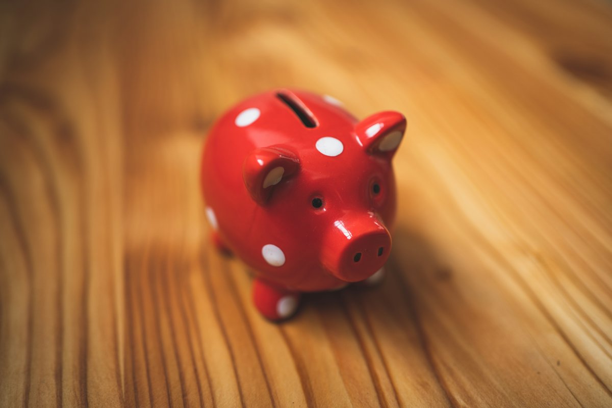 Red polka-dot piggy bank on a wooden floor